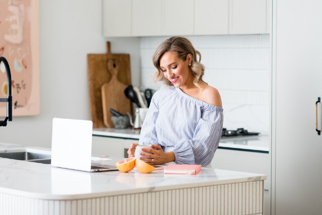 starting an online business in australia: woman in front of laptop at kitchen bench.